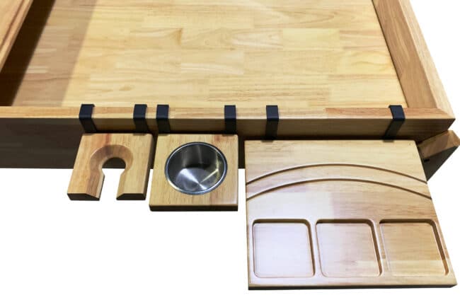 The nilo flip shelf, cup holder, and wine glass holder shown on the Nilo Master Table, a board gaming table.