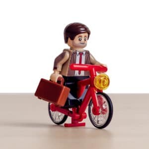 Adult Lego character biking towards the best lego table for adults